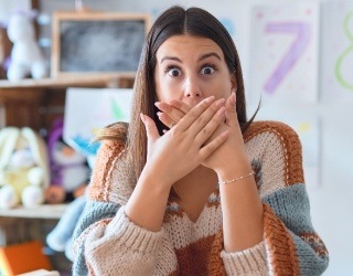 Woman with knocked out tooth covering her mouth