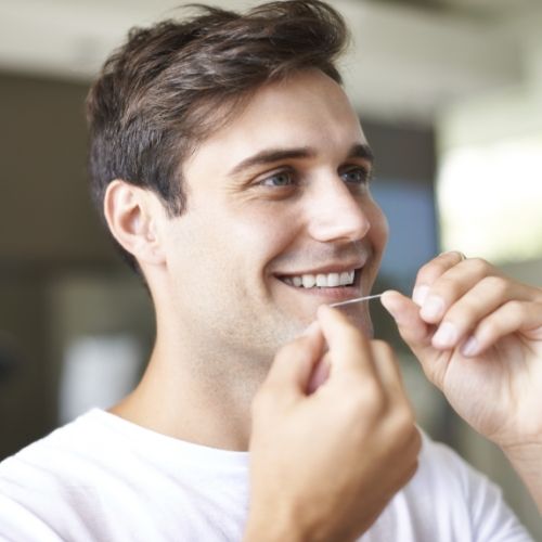 Man flossing to prevent dental emergencies