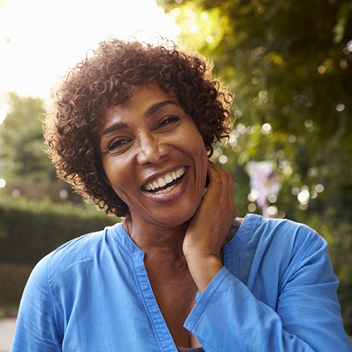 woman smiling brightly with dental implants in Holliston 