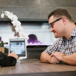 Dentist and patient looking at x-rays on tablet computer