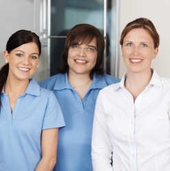 Three smiling dental team members