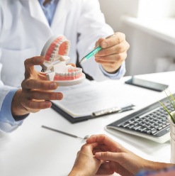 Dentist pointing to smile model