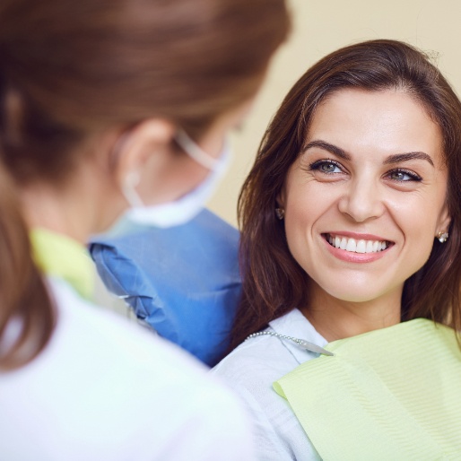 Woman in dental chair smiling at dentist