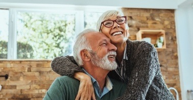 Man and woman with flawless smiles after restorative dentistry