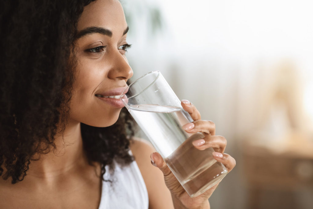 person drinking water to prevent winter mouth issues in Holliston