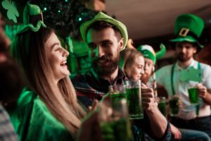 People in St. Patrick's Day outfits drinking green beer